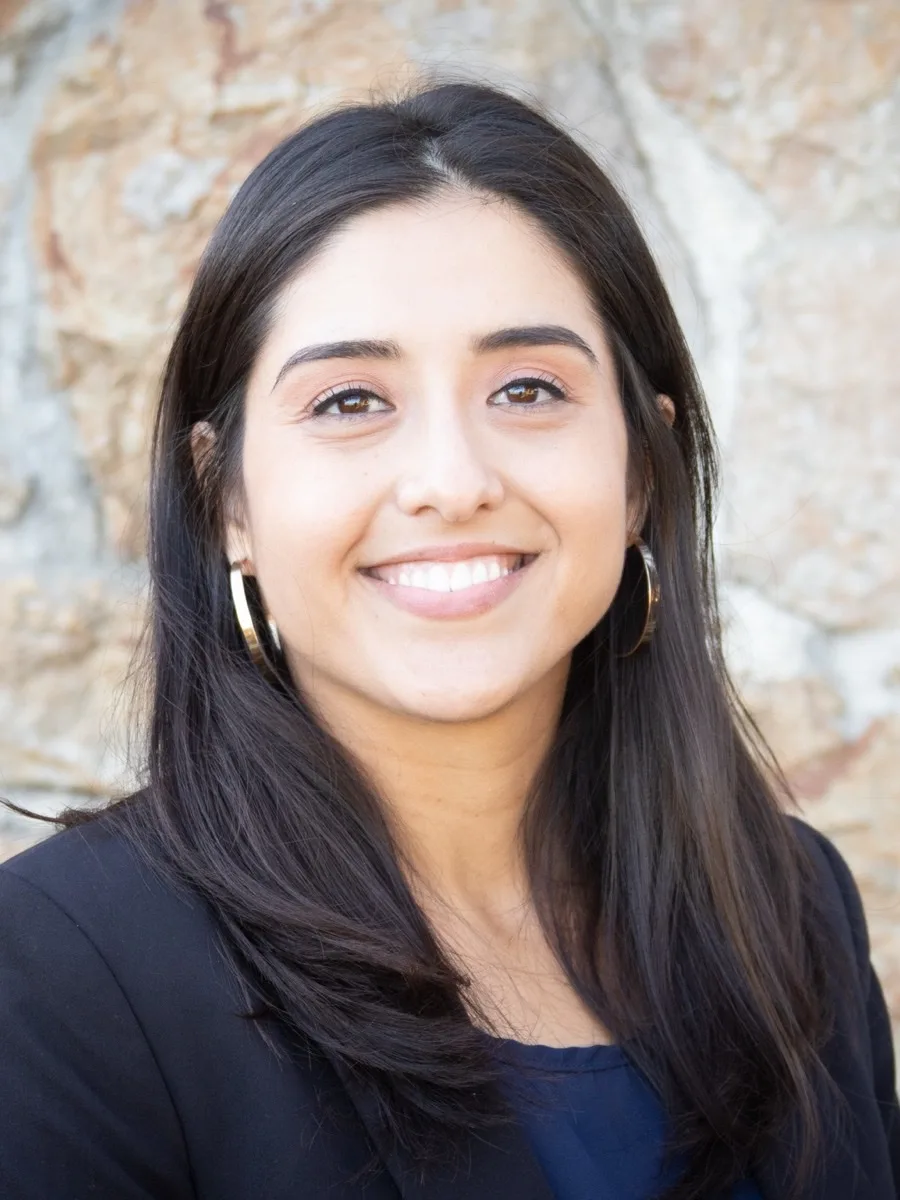 Dr. Demi Orozco, Psy.D., photographed against a stone wall
