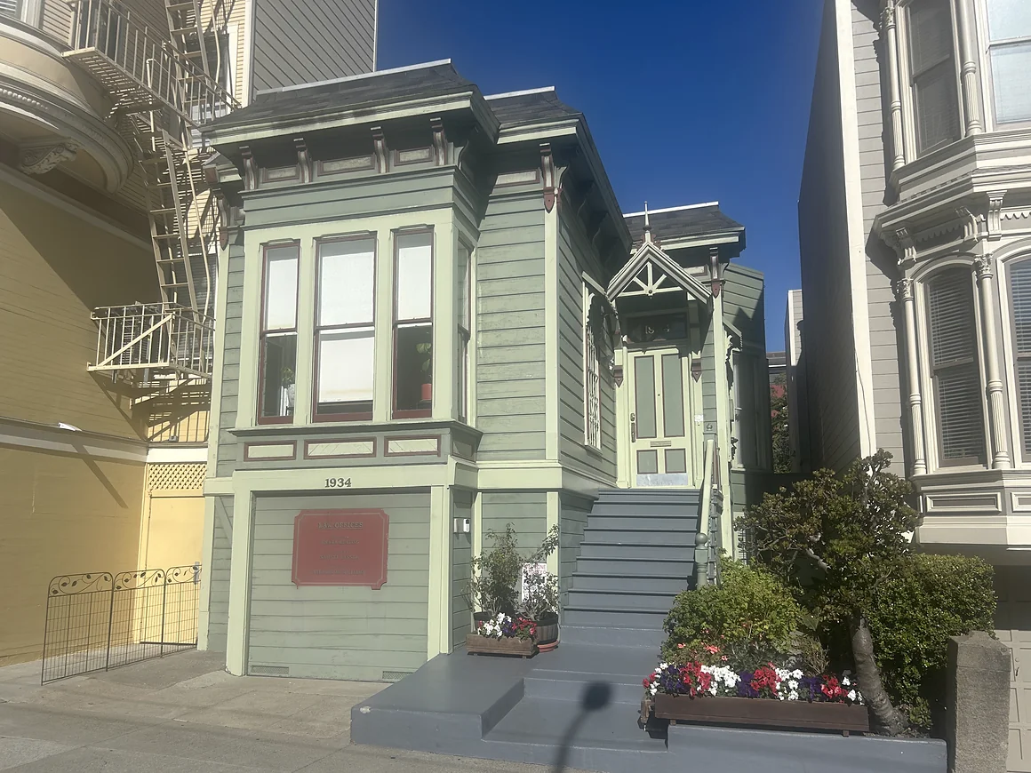 The practice's building at 1934 Divisadero Street: a pale green Victorian with a bay window, a gabled porch, and painted steps up to the front door